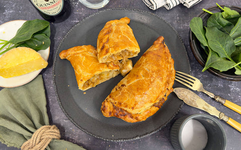 Creamy cheese and potato filling oozing from a crisp golden pasty shell